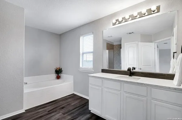a bathroom with a sink a large mirror and a bathtub