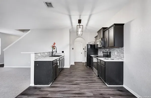 a kitchen with stainless steel appliances granite countertop a sink stove and refrigerator