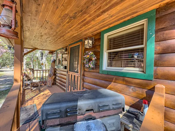 a view of balcony with wooden floor and fence and a couple of potted plants
