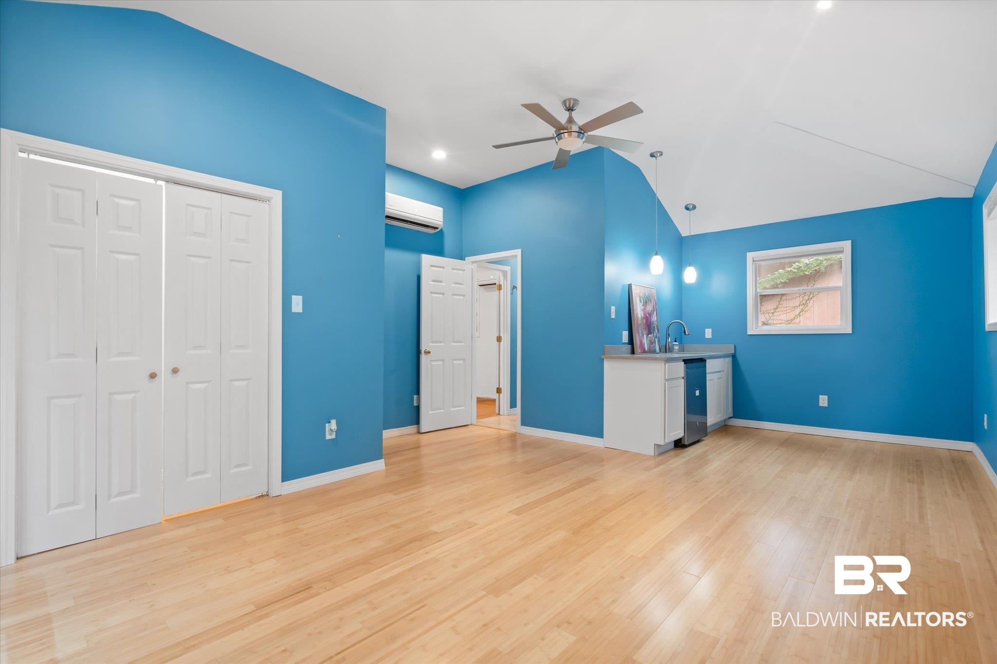 14 South Monterey Street Mobile, AL 36604 - Photo 21 of 41 Unfurnished living room featuring vaulted ceiling, sink, ceiling fan, light wood-type flooring, and an AC wall unit