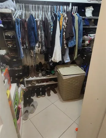 a view of walk in closet with clothes and shoes