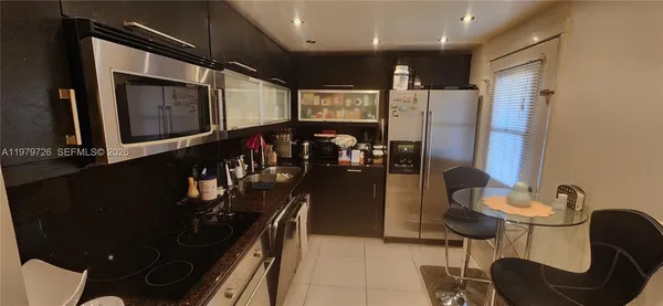 a kitchen with stainless steel appliances kitchen island granite countertop a stove and a sink