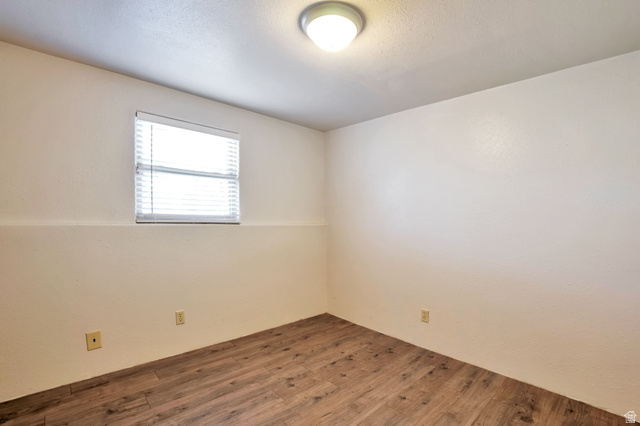 1057 North 700 West Clinton, UT 84015 - Photo 14 of 15 Empty room featuring wood finished floors and a textured wall