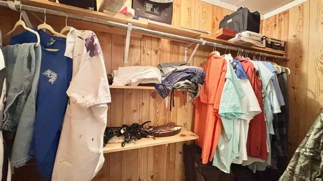 a view of walk in closet with clothes and shoes