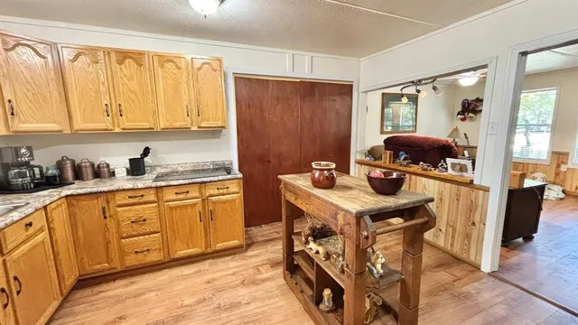 a kitchen with stainless steel appliances granite countertop a stove top oven a sink dishwasher and cabinets with wooden floor