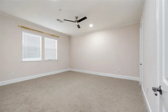 an empty room with a window and a fan