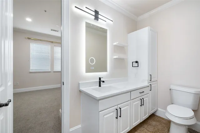 a bathroom with a double vanity sink and mirror with toilet
