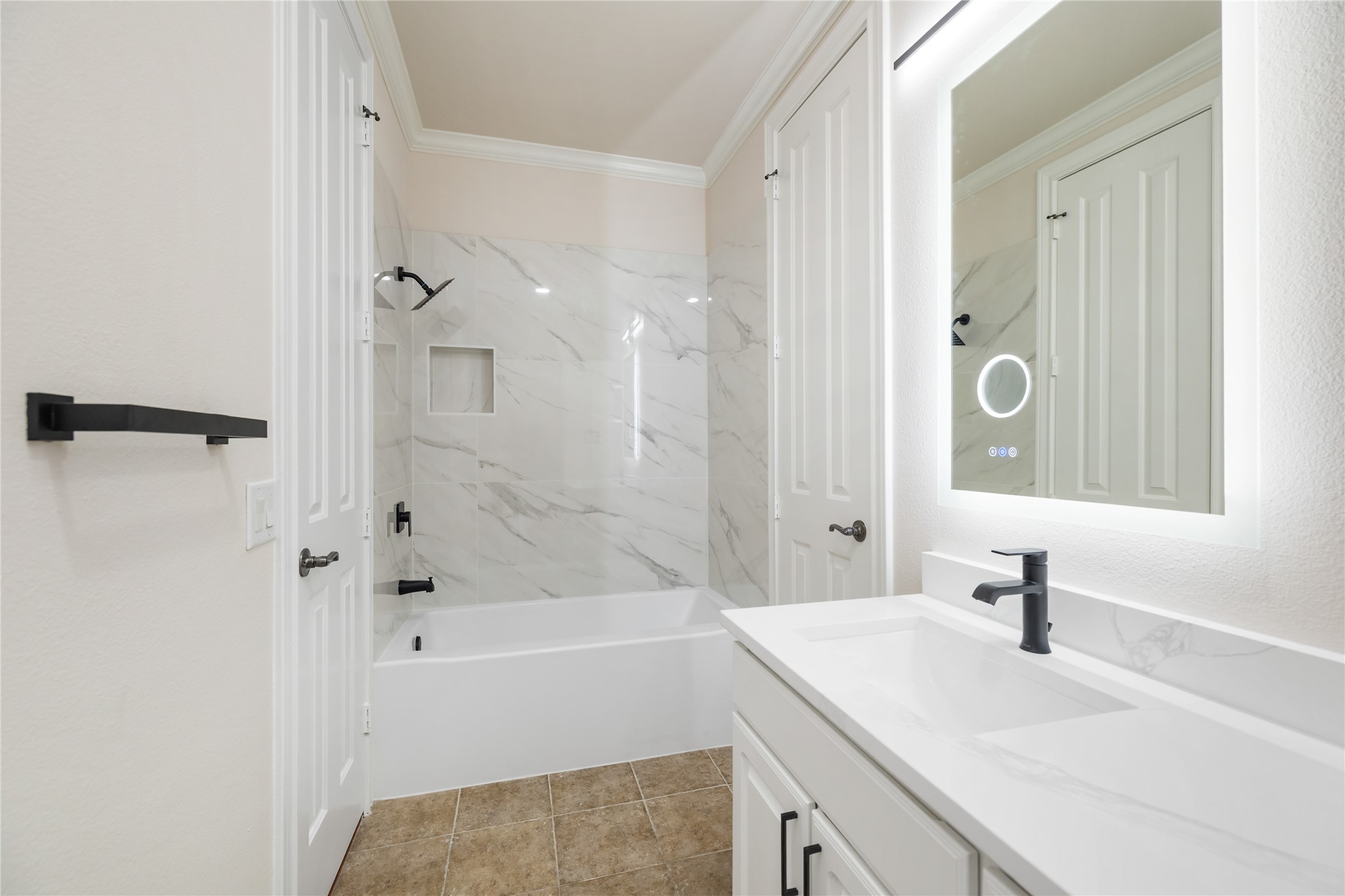7134 Mapleridge Street, Unit 3G Houston, TX 77081 - Photo 20 of 26 a bathroom with a sink a mirror and a bathtub