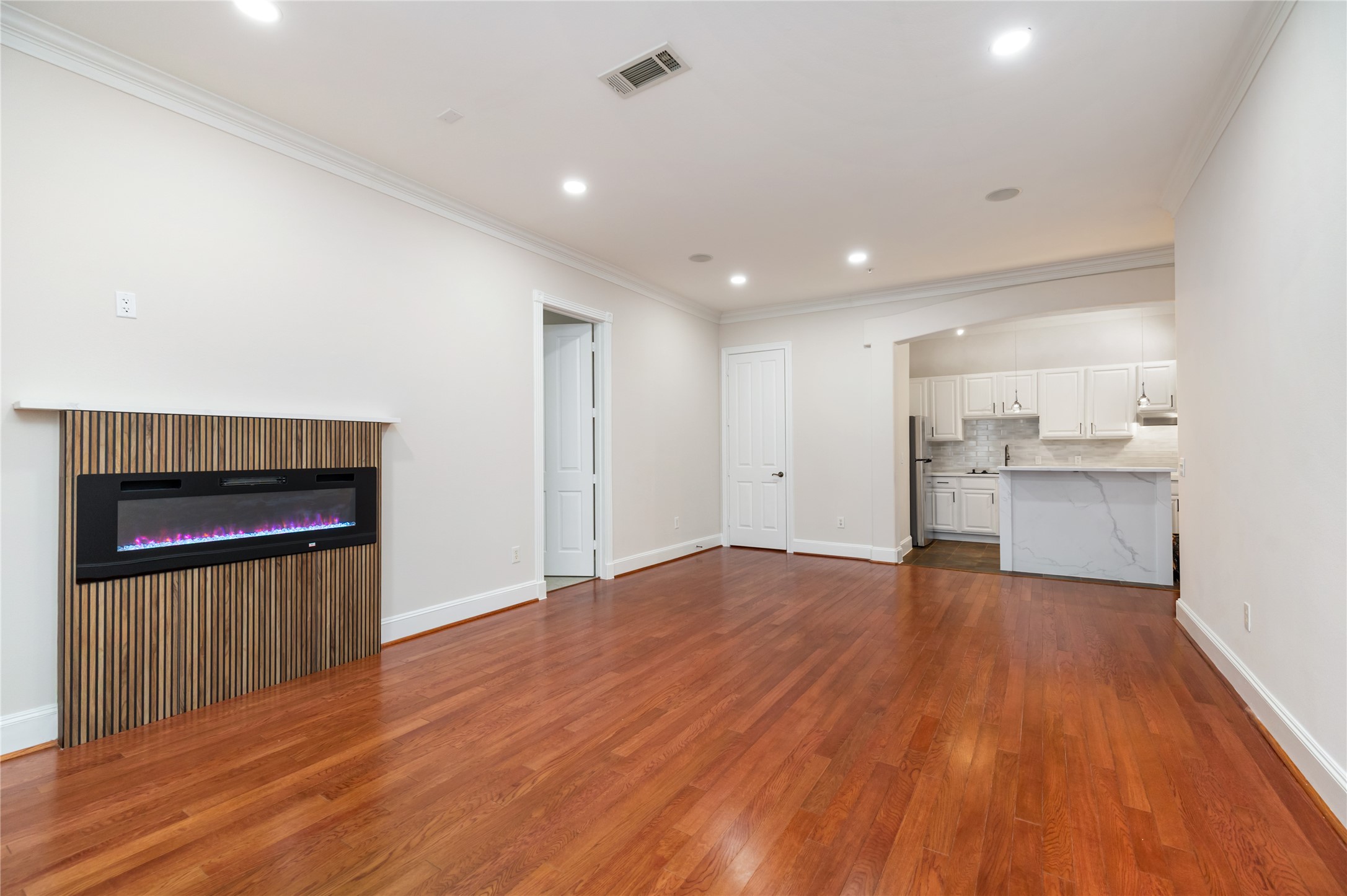 7134 Mapleridge Street, Unit 3G Houston, TX 77081 - Photo 10 of 26 a view of empty room with wooden floor and kitchen