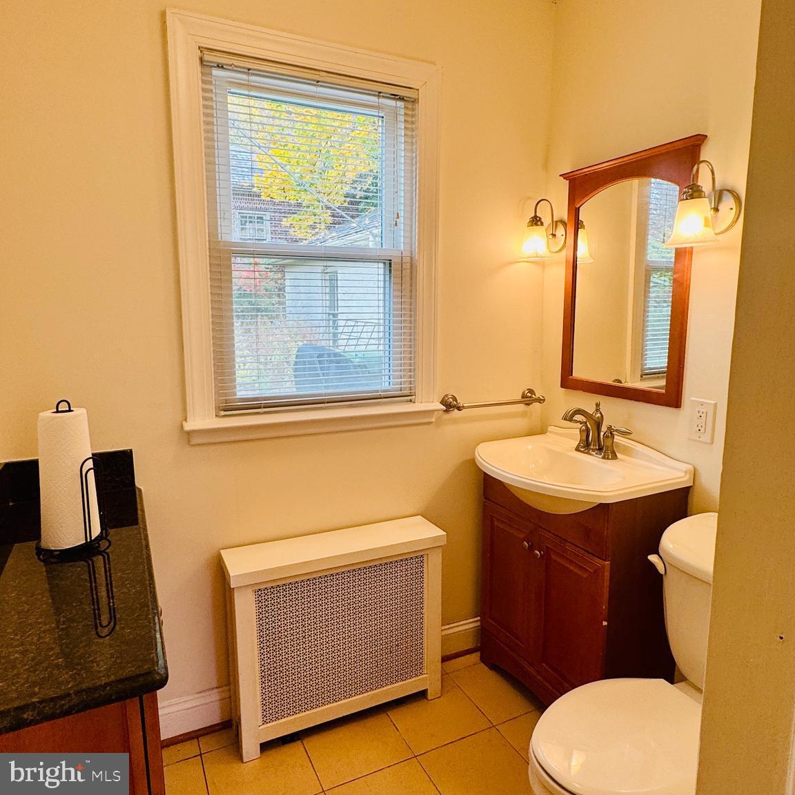 3902 Hadley Square West Baltimore, MD 21218 - Photo 12 of 38 a bathroom with a granite countertop toilet sink and mirror