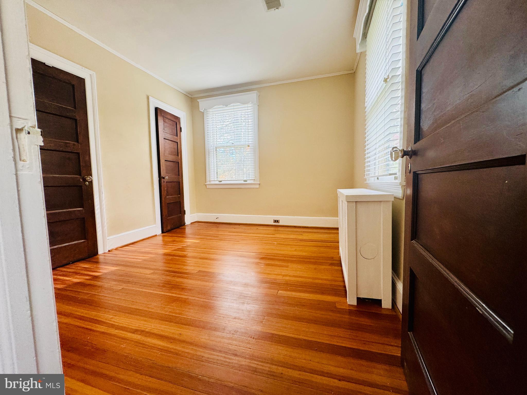 3902 Hadley Square West Baltimore, MD 21218 - Photo 21 of 38 a view of an empty room with wooden floor and a window