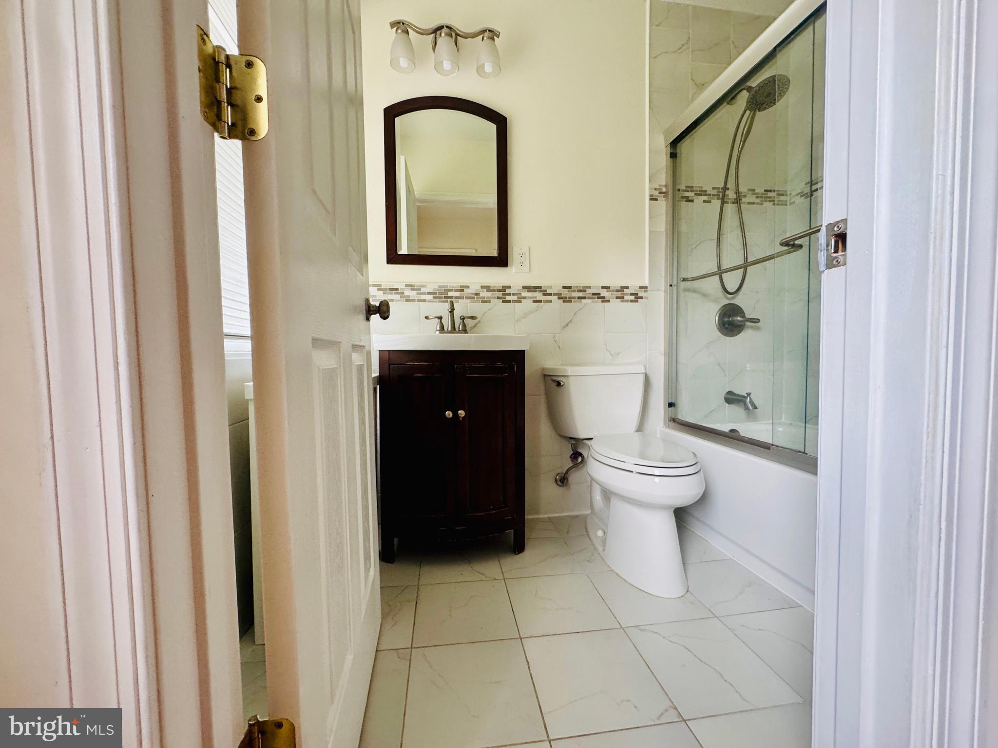 3902 Hadley Square West Baltimore, MD 21218 - Photo 23 of 38 a bathroom with a toilet sink and mirror