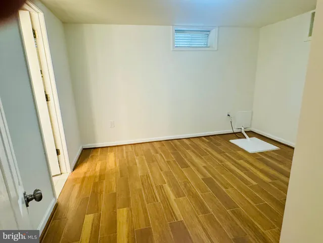 a view of a room with wooden floor and door