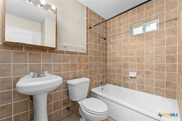 a bathroom with a sink a toilet and bathtub