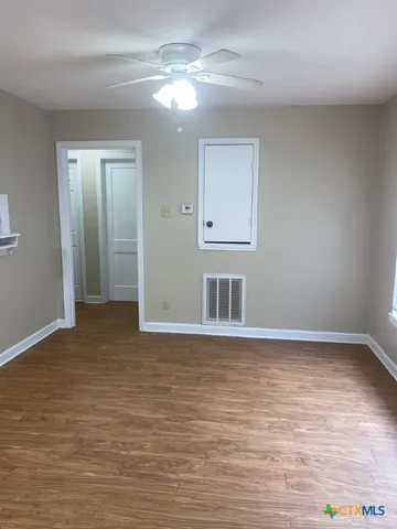 a view of an empty room with wooden floor