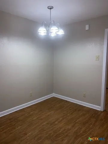a view of a room with wooden floor and chandelier