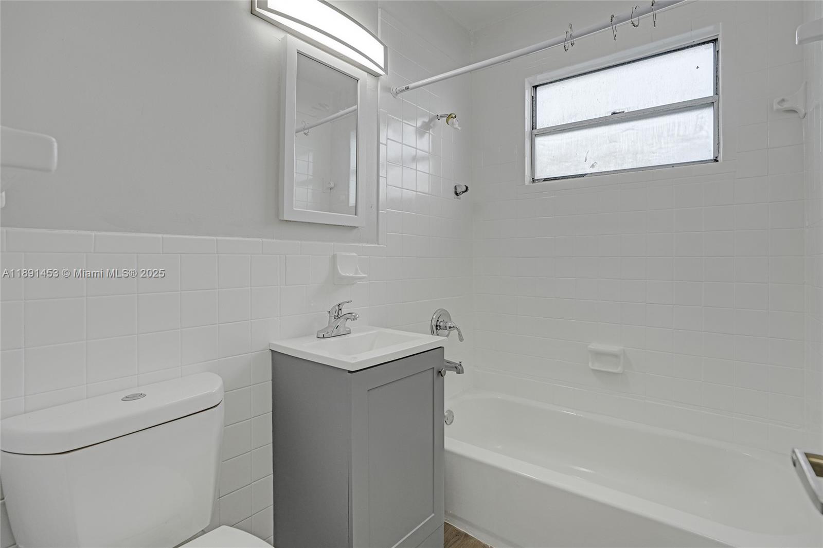 14100 Northwest 24th Court, Unit 303 Opa-Locka, FL 33054 - Photo 16 of 21 a bath room with a toilet a sink and a bath tub