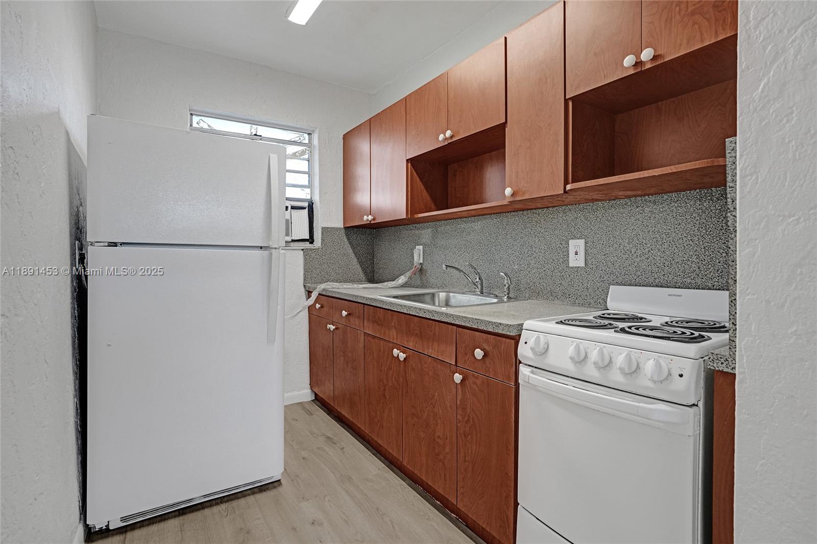 14100 Northwest 24th Court, Unit 303 Opa-Locka, FL 33054 - Photo 2 of 21 a kitchen with a refrigerator stove and microwave