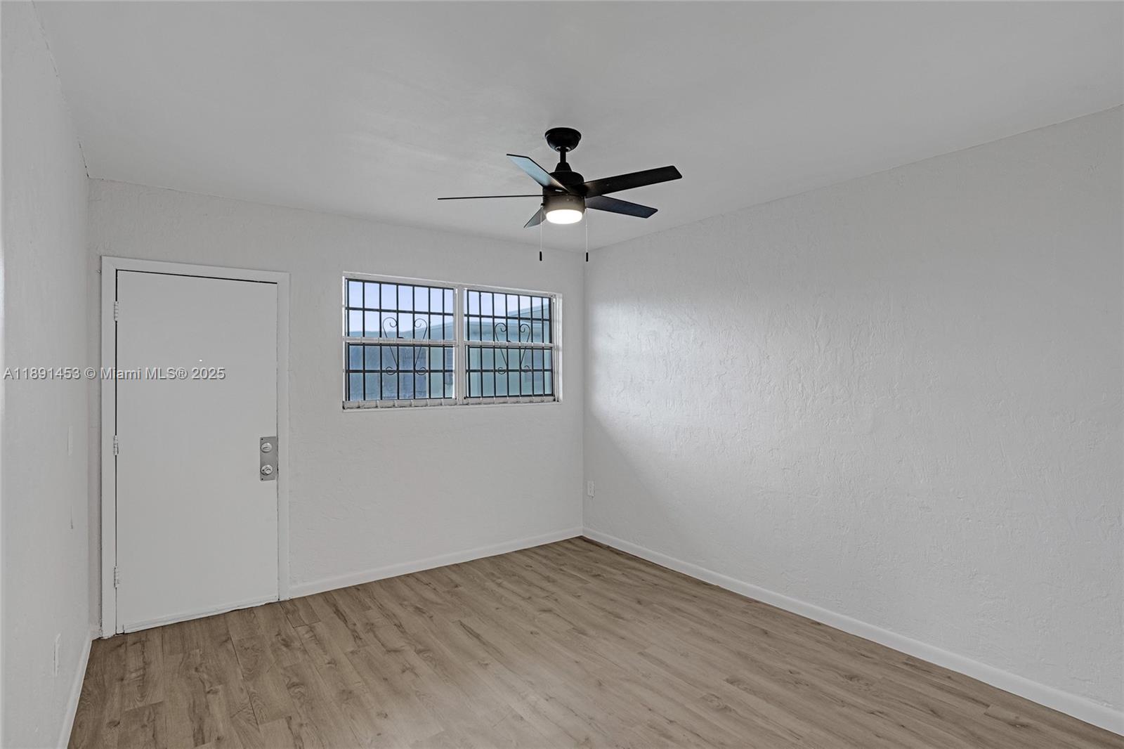14100 Northwest 24th Court, Unit 303 Opa-Locka, FL 33054 - Photo 5 of 21 wooden floor in an empty room with a window
