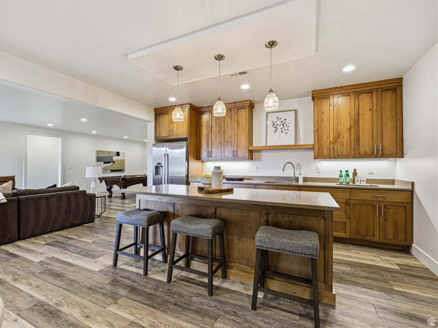 402 Shadow Hill Road Wanship, UT 84017 - Photo 43 of 90 Kitchen featuring wood finish cabinets, a breakfast bar, light wood-style flooring, and high quality fridge