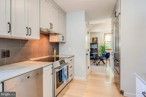 a kitchen with stainless steel appliances granite countertop a refrigerator and a stove
