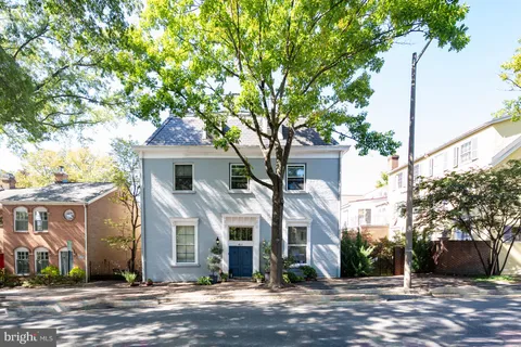 a view of a house with a yard and potted plants