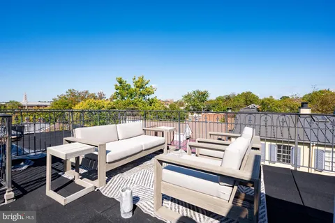 a view of a patio with couches table and chairs and potted plants