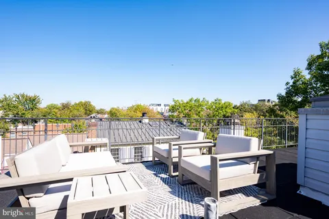 a view of a building with potted plants and a bench