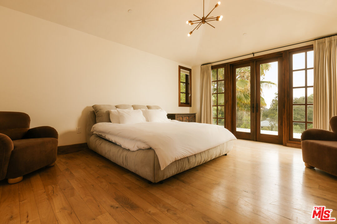 1105 Rivas Canyon Road Pacific Palisades, CA 90272 - Photo 41 of 49 a bedroom with a bed couch and a large window
