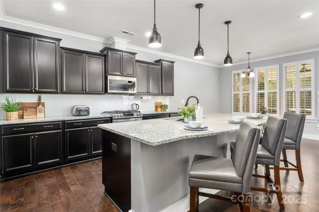 a kitchen with kitchen island a cabinets a sink and a stove
