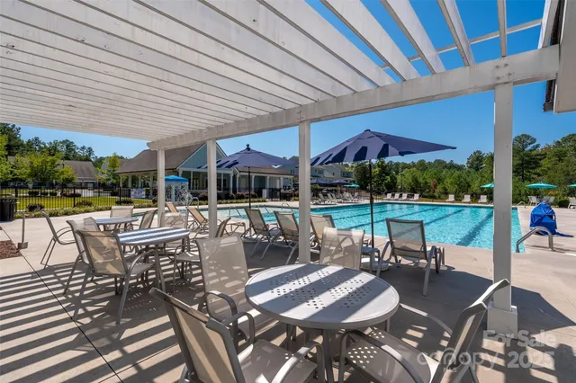 a view of a patio with a yard table and chairs under an umbrella