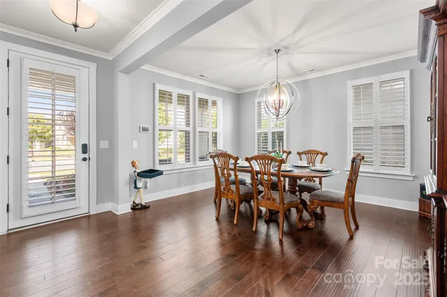 a very nice looking dining room with a window and wooden floor