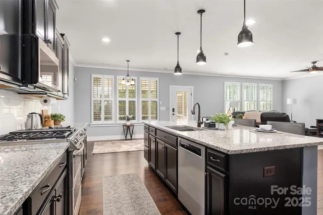 a kitchen with granite countertop wooden cabinets a stove a oven and a refrigerator with wooden floor