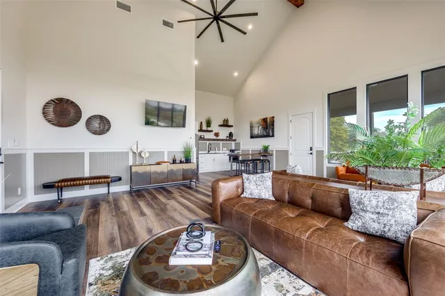 a living room with furniture kitchen view and a large window