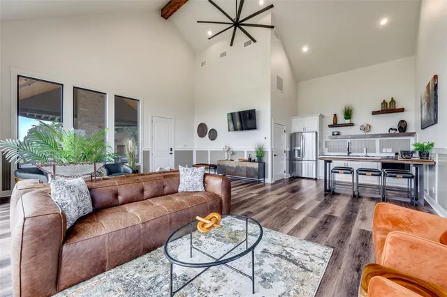 a kitchen with stainless steel appliances a table chairs refrigerator and wooden floor