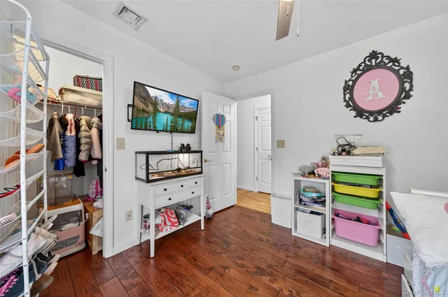 a hallway with white cabinets and wooden floor