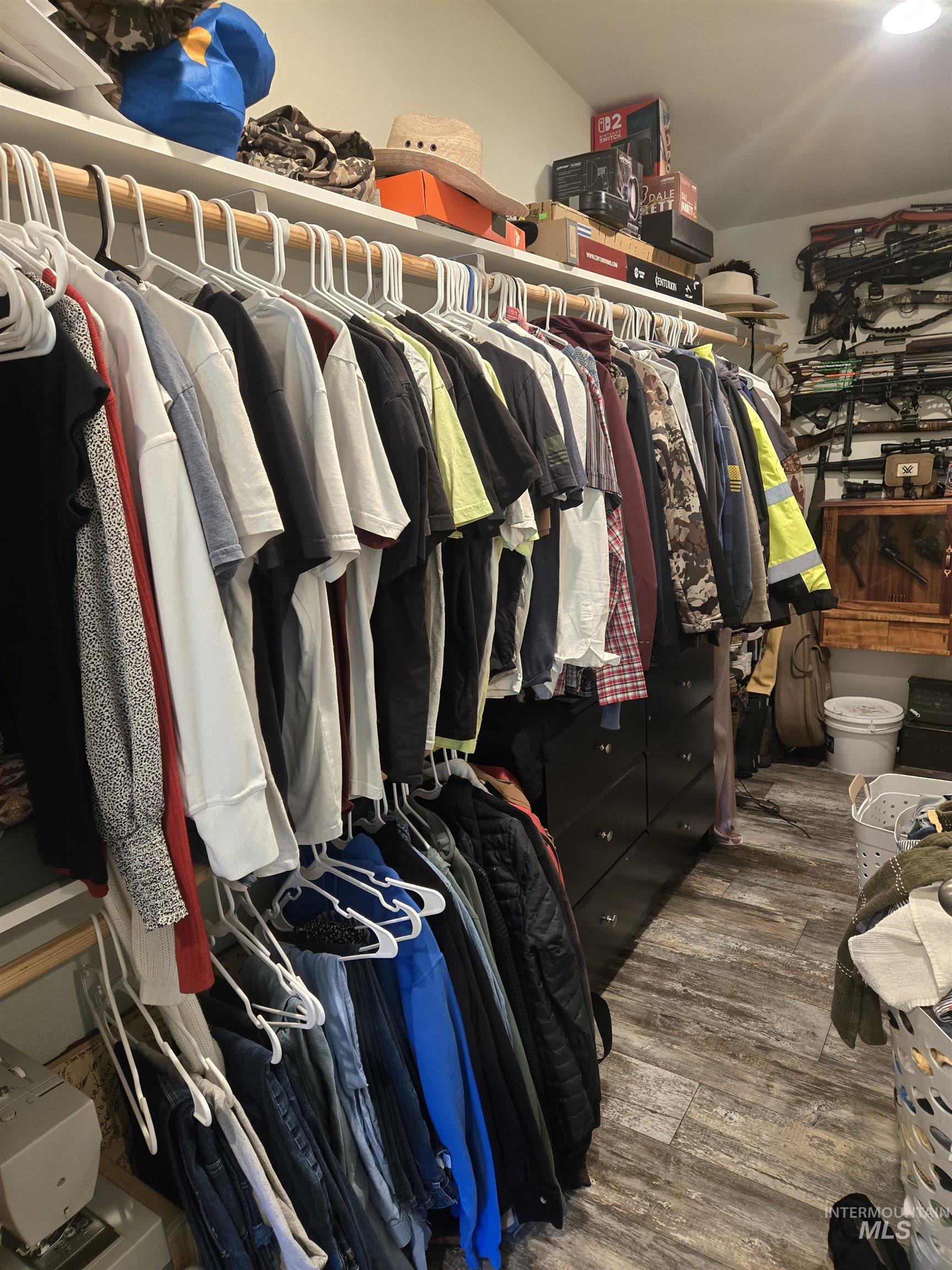174 Konkolville Road Orofino, ID 83544 - Photo 20 of 43 Organized closet space featuring extensive hanging rods, upper storage shelving, and wood-finish flooring