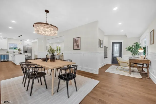 a living room with stainless steel appliances kitchen island hardwood floor sink stove and table