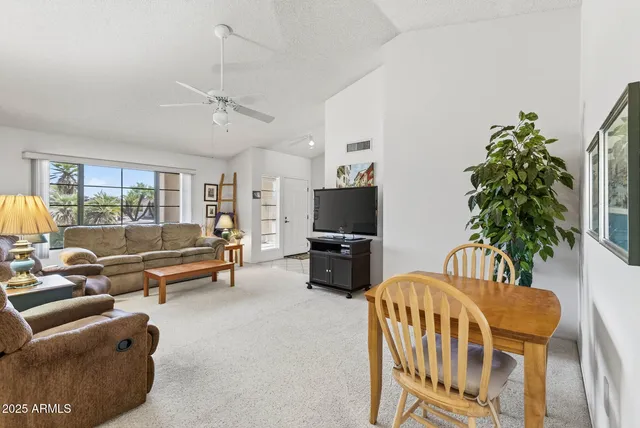 a living room with furniture a flat screen tv and a large window