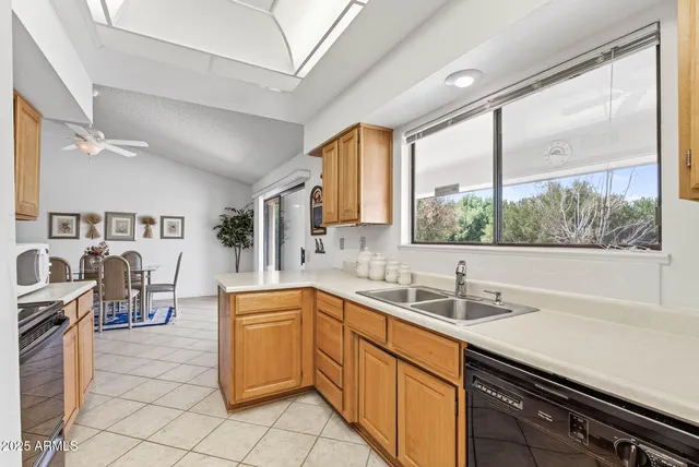 a kitchen with a sink window and cabinets