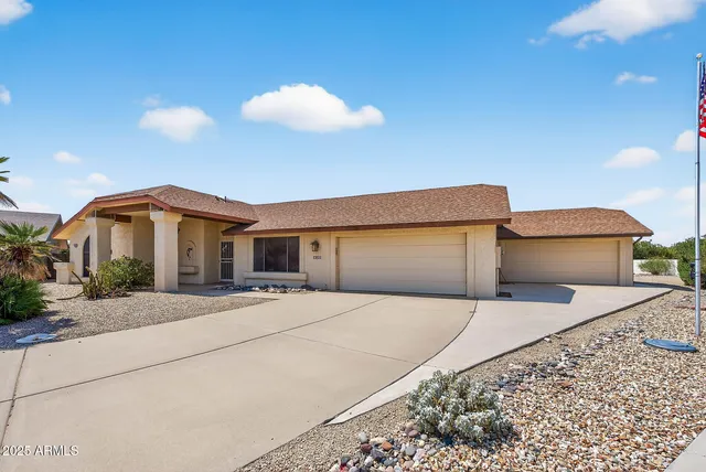a front view of house with yard and trees in the background