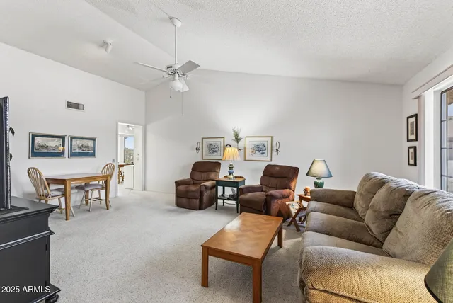 a living room with furniture a ceiling fan and a rug
