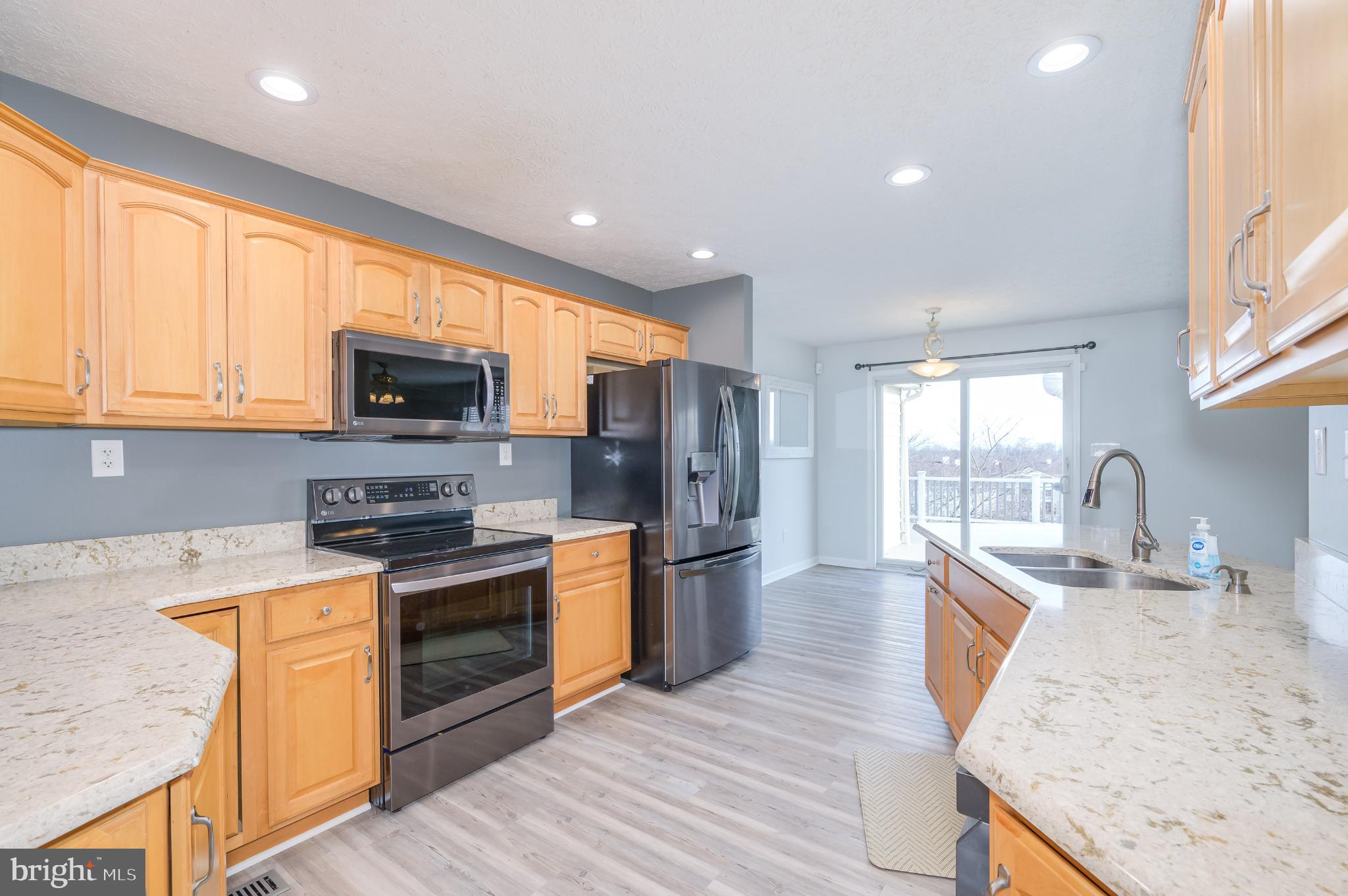 490 Renaissance Drive Martinsburg, WV 25403 - Photo 14 of 73 a large kitchen with stainless steel appliances granite countertop a stove a sink dishwasher and a microwave with wooden floor