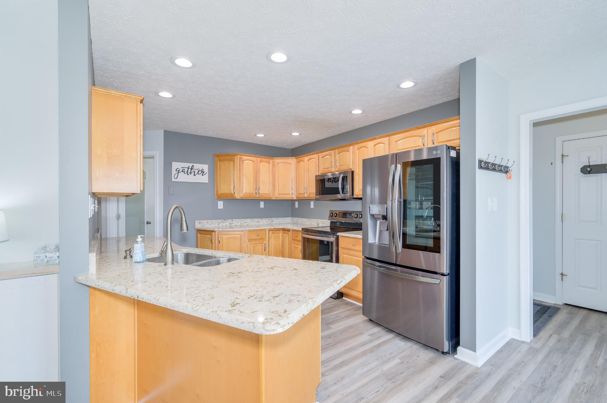 490 Renaissance Drive Martinsburg, WV 25403 - Photo 18 of 73 a kitchen with stainless steel appliances granite countertop a refrigerator a sink dishwasher and a stove with wooden floor