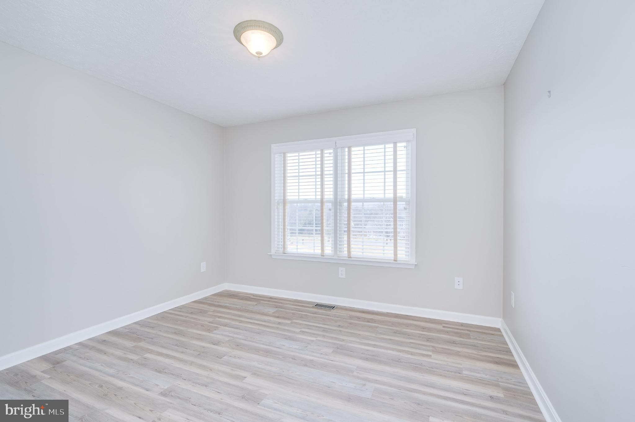 490 Renaissance Drive Martinsburg, WV 25403 - Photo 28 of 73 an empty room with wooden floor and windows