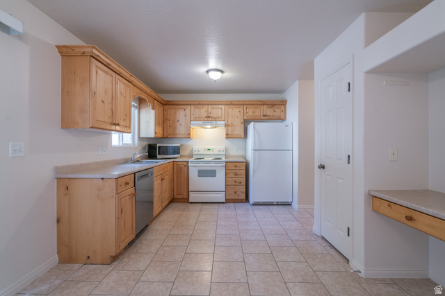 1735 West 540 North, Unit 1805 St. George, UT 84770 - Photo 18 of 64 Spacious kitchen featuring light wood cabinetry, a stainless steel dishwasher, and a white refrigerator