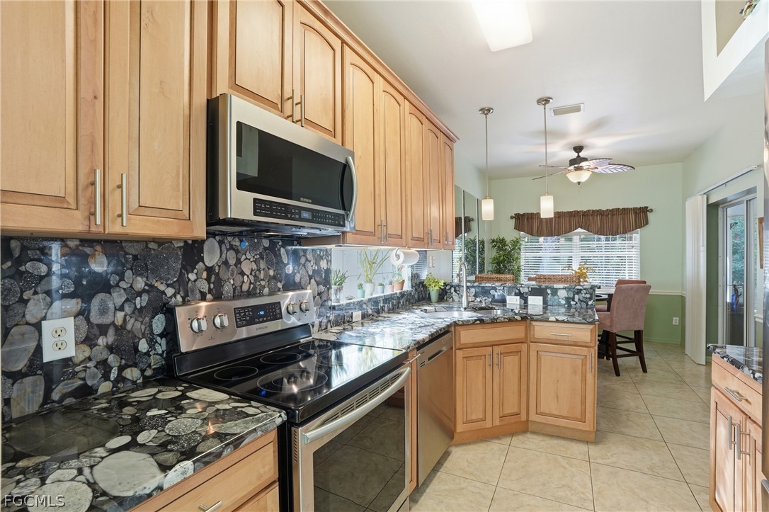 10730 Rio Mar Circle Estero, FL 33928 - Photo 11 of 47 a kitchen with a stove a sink and a microwave