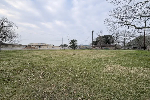 a view of a green field with wooden fence