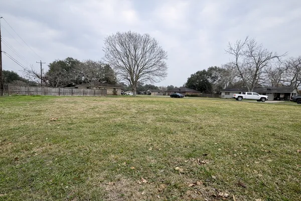 a view of a field with an trees in front of it