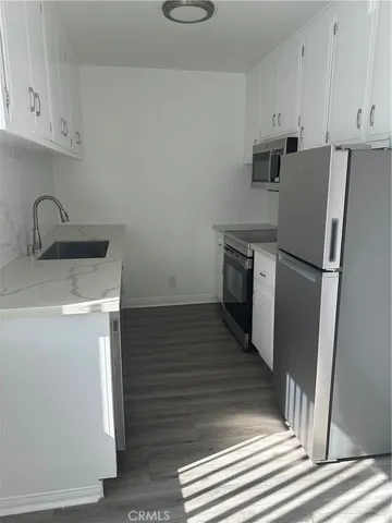 a kitchen with a refrigerator sink and cabinets